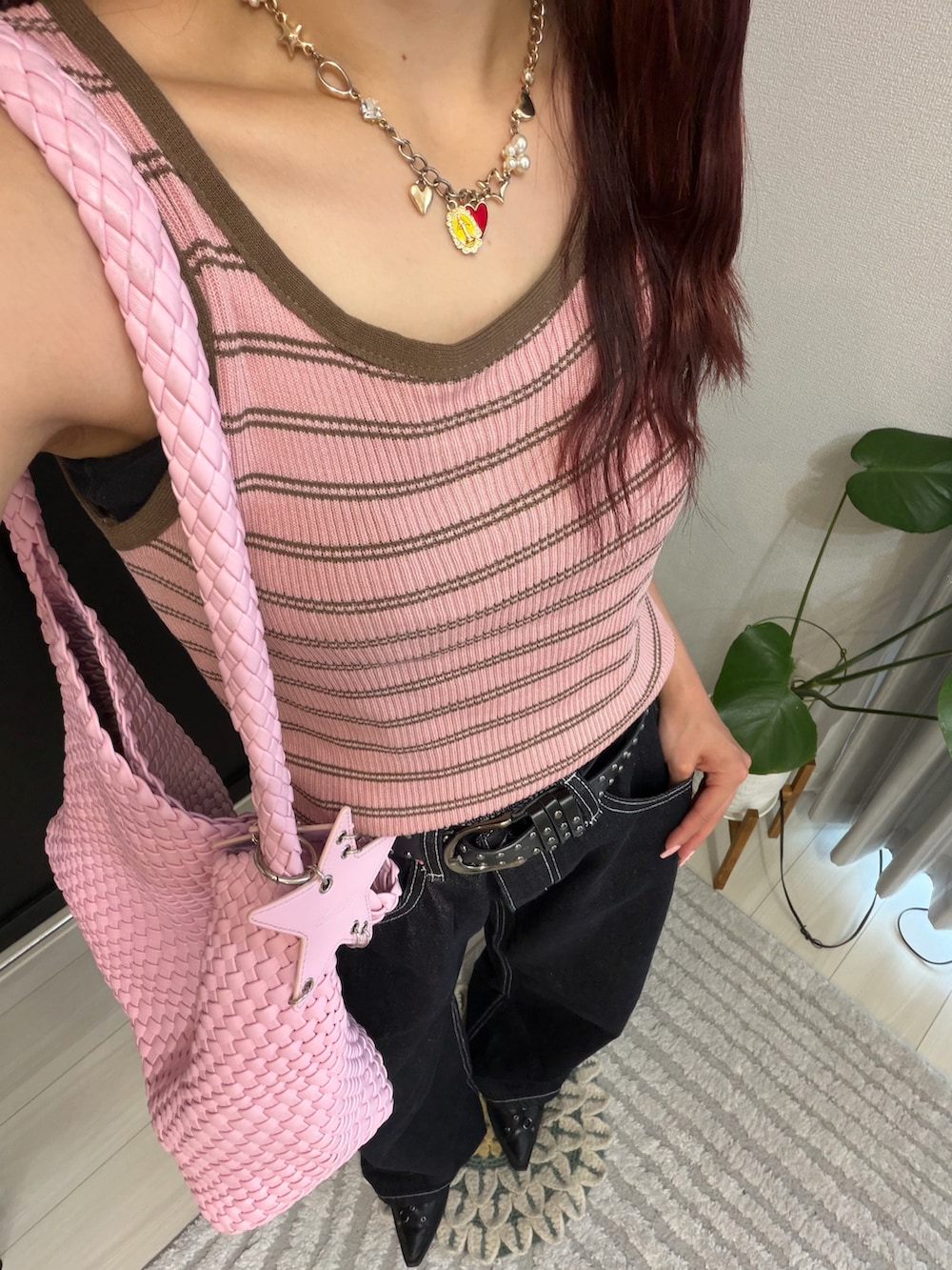ブラック系のサンダル、ピンク系のバッグ、ブラック系のデニムパンツを着用したレディースの夏コーディネートの2枚目の写真