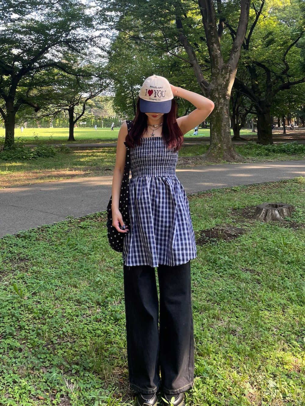 ブラック系のバッグ、ブルー系のスカート、ブラック系のデニムパンツを着用したレディースの春コーディネートの2枚目の写真