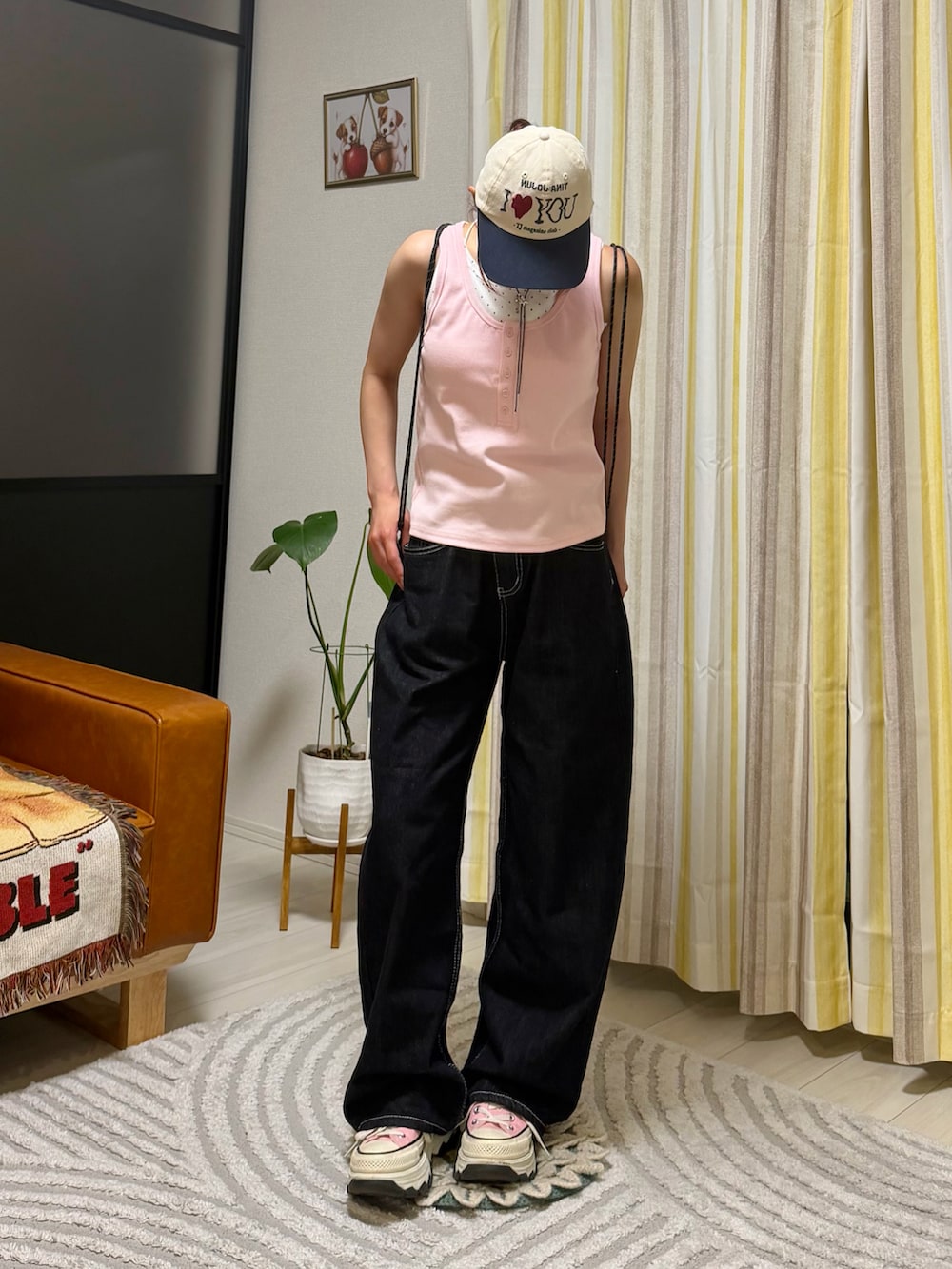 ピンク系のタンクトップ、ブラック系のデニムパンツ、ピンク系のスニーカーを着用したレディースの春コーディネートの4枚目の写真
