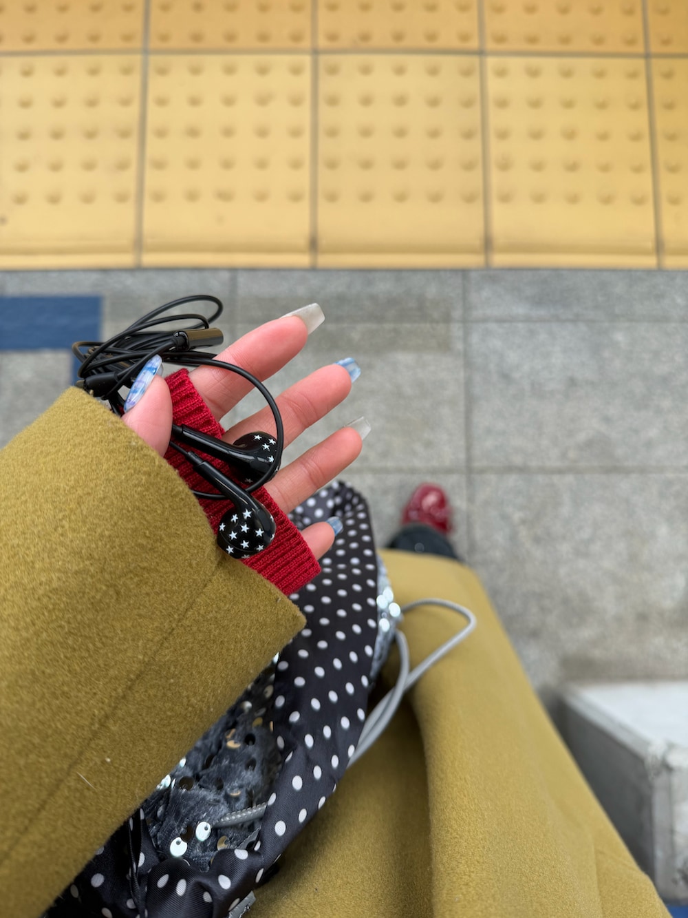 イエロー系のダウンジャケット/コート、レッド系のニット/セーター、ブラック系のフォーマルスーツ/小物を着用したレディースの冬コーディネートの2枚目の写真