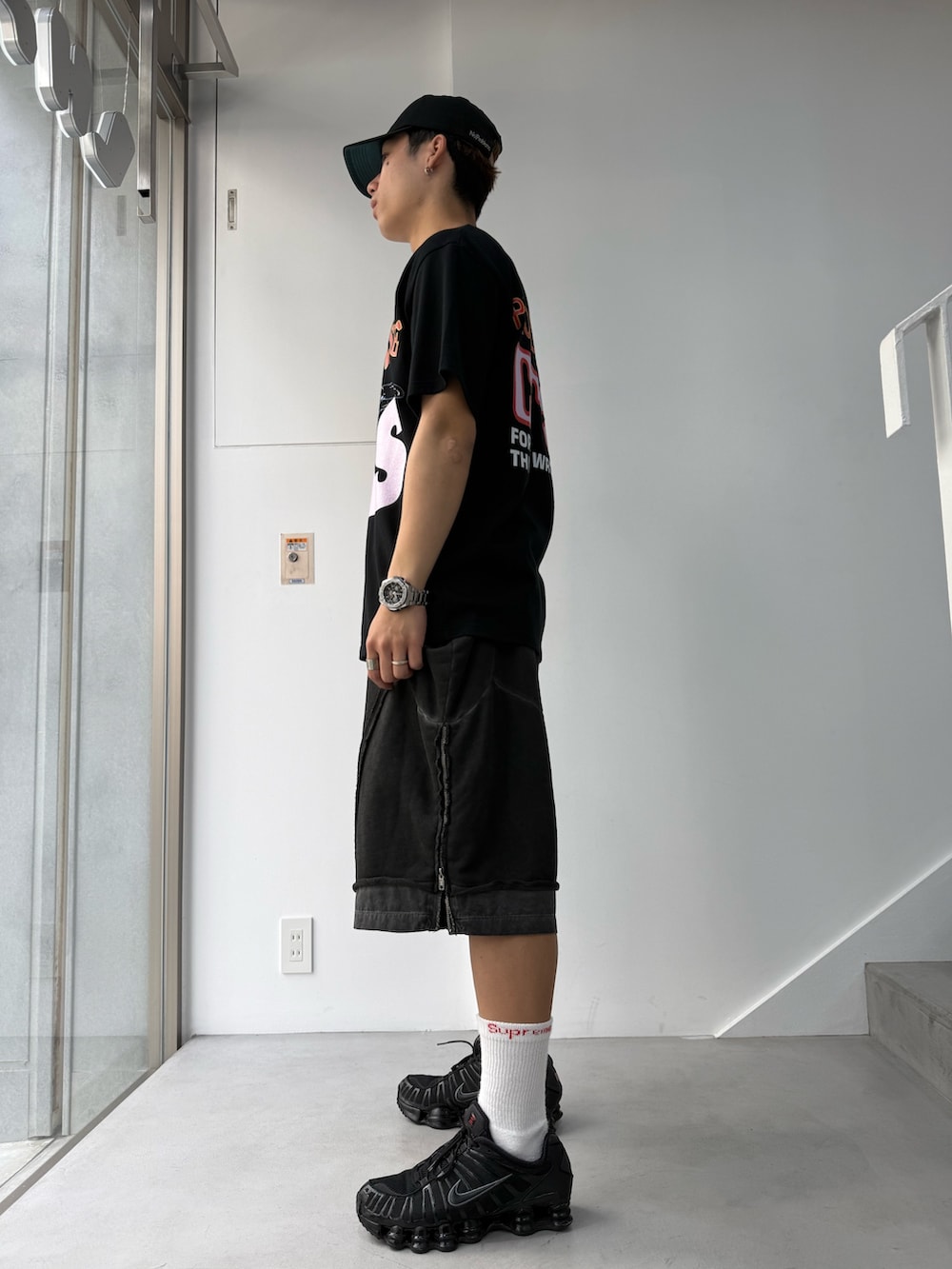 グレー系のスウェットパンツ、ブラック系のTシャツ/カットソーを着用したメンズの春コーディネートの2枚目の写真
