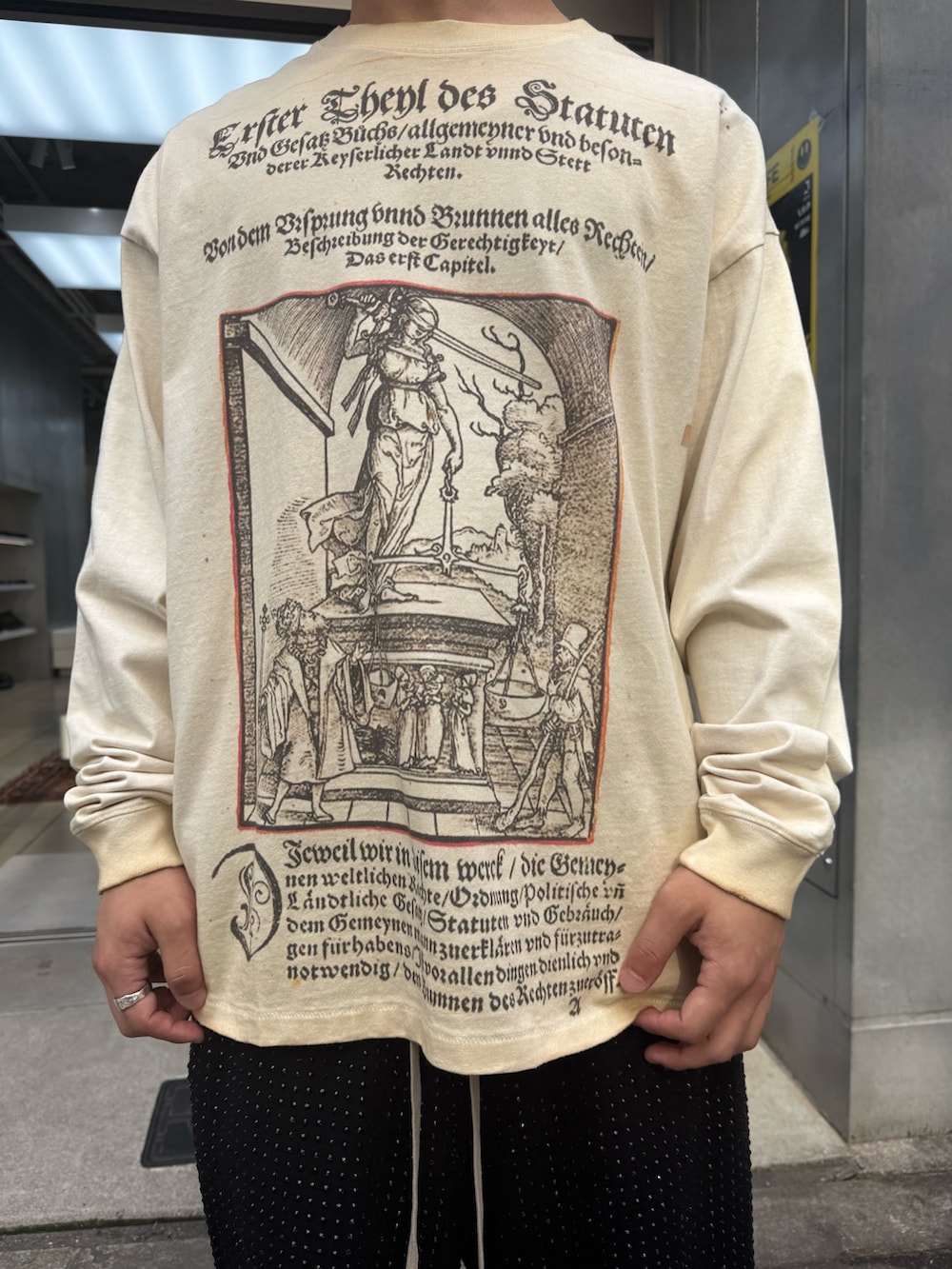ベージュ系のTシャツ/カットソー、ブラック系のスウェットパンツを着用したメンズの夏コーディネートの4枚目の写真