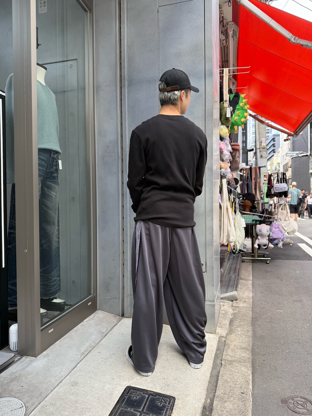 ブラック系のトップス、グレー系のパンツを着用したメンズの秋コーディネートの3枚目の写真