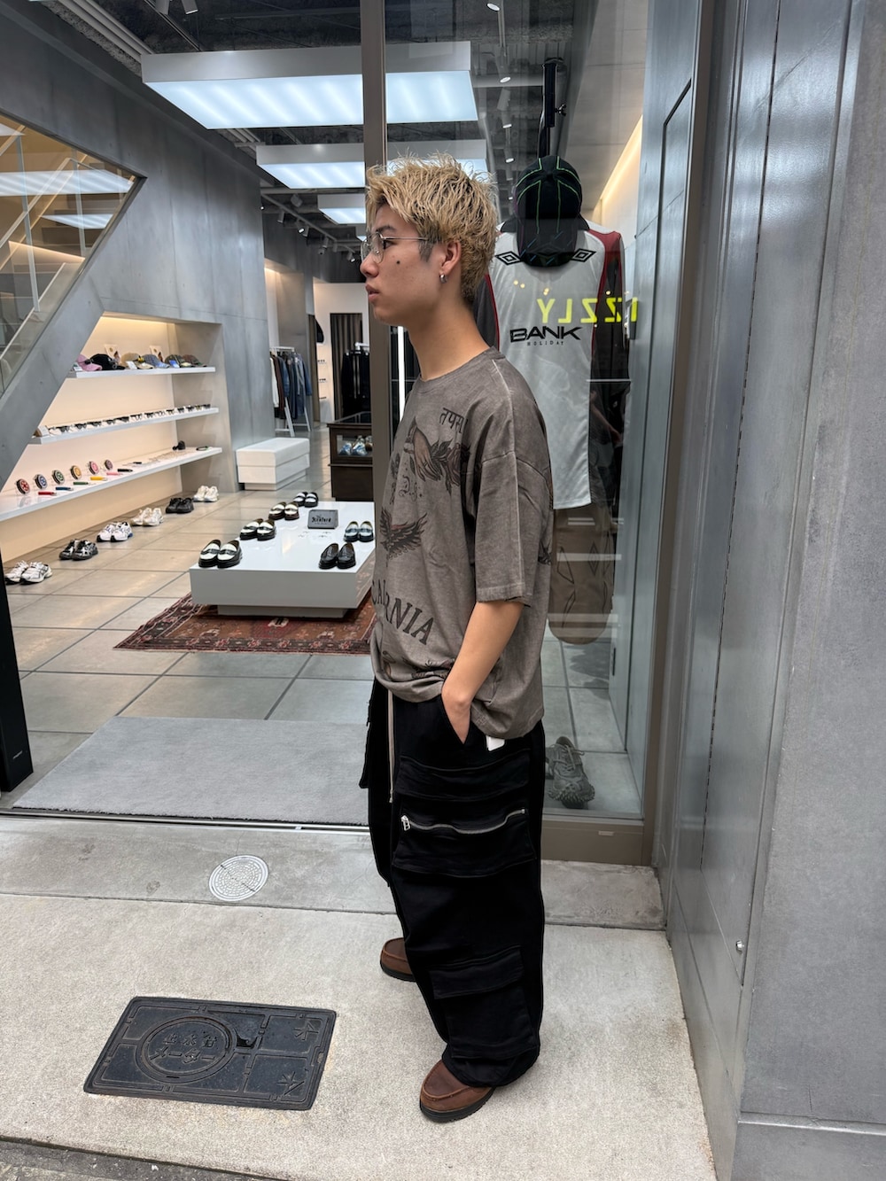 ブラック系のカーゴパンツ、ベージュ系のTシャツ/カットソーを着用したメンズの夏コーディネートの6枚目の写真