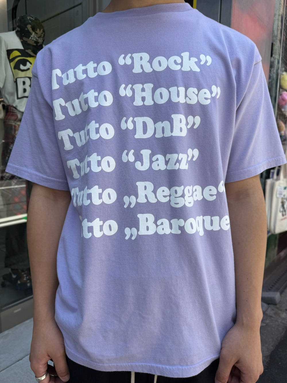 パープル系のTシャツ/カットソー、ブラック系のその他パンツ、ブラック系のローファーを着用したメンズの夏コーディネートの4枚目の写真