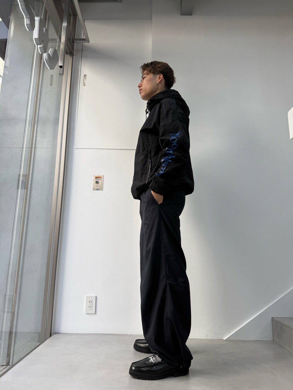 ブラック系のナイロンジャケットを着用したメンズの春コーディネートの2枚目の写真