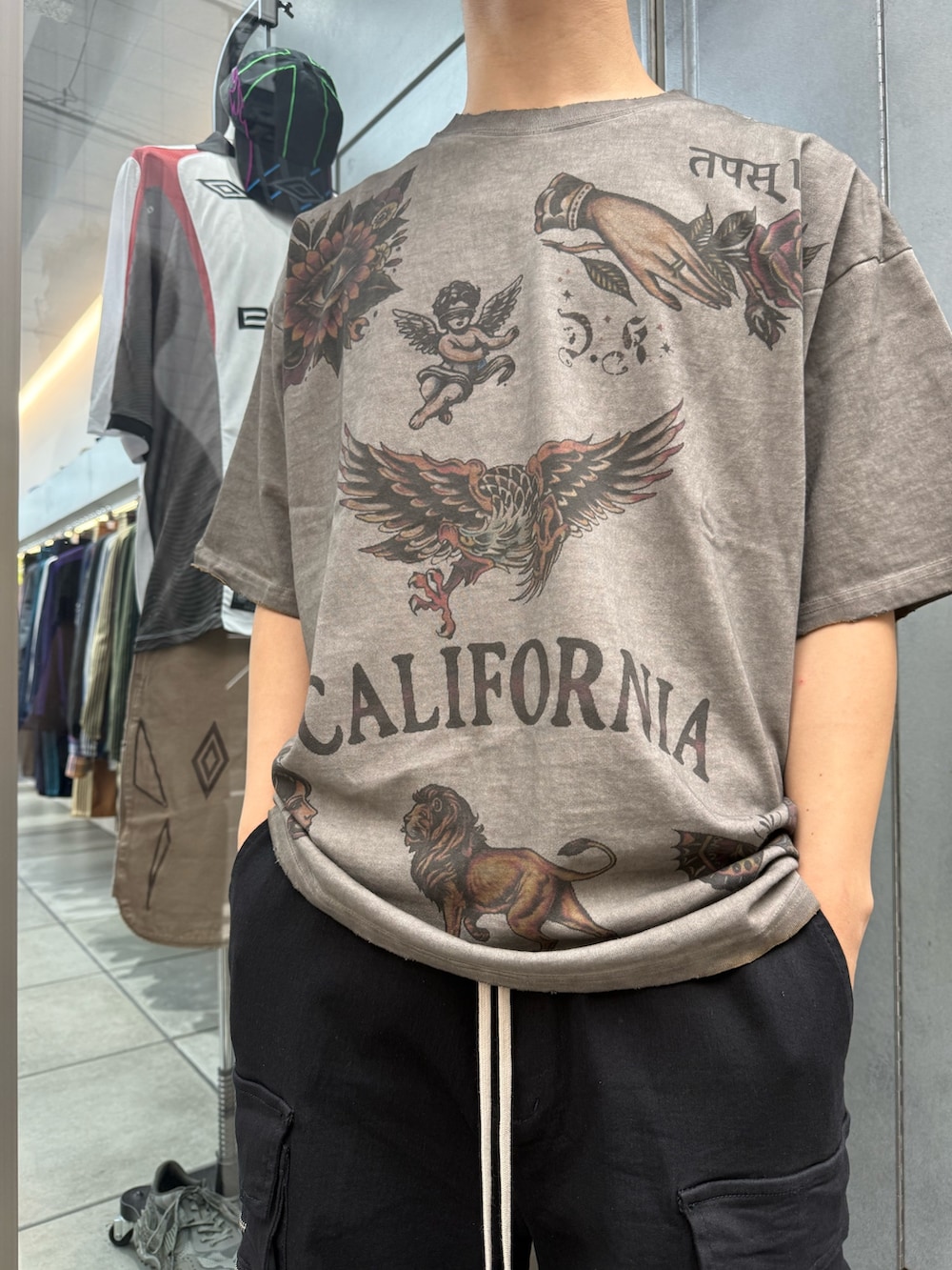ブラック系のカーゴパンツ、ベージュ系のTシャツ/カットソーを着用したメンズの夏コーディネートの4枚目の写真