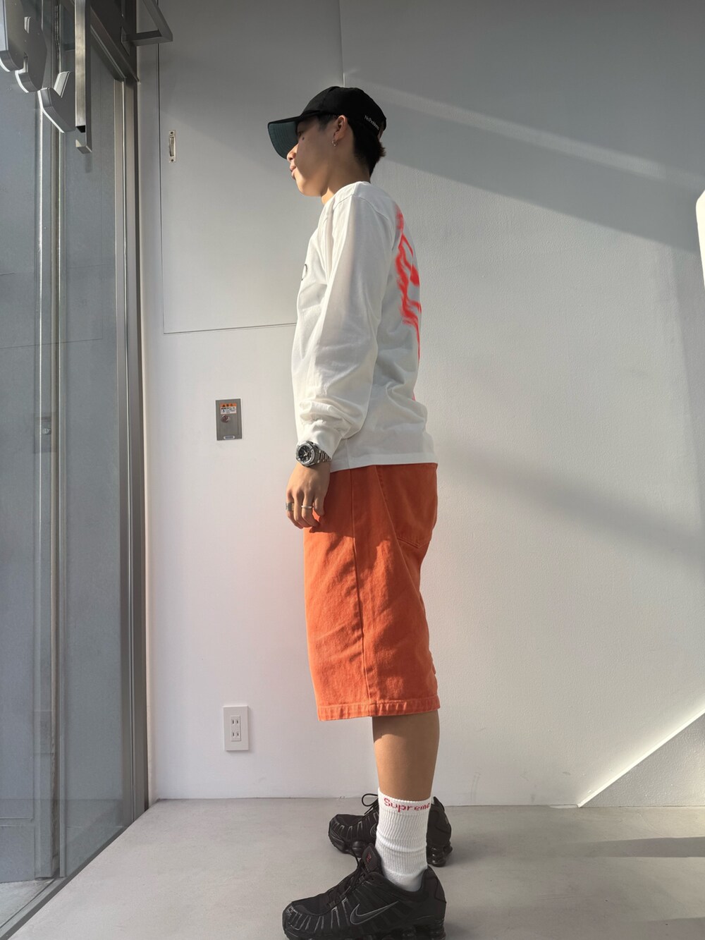 ホワイト系のTシャツ/カットソー、オレンジ系のデニムパンツを着用したメンズの春コーディネートの2枚目の写真