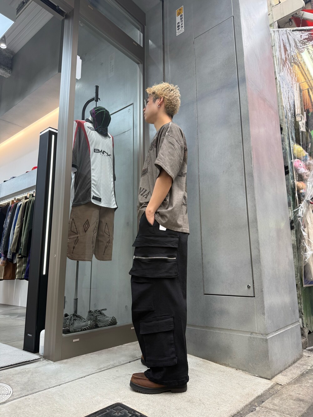 ブラック系のカーゴパンツ、ベージュ系のTシャツ/カットソーを着用したメンズの夏コーディネートの2枚目の写真