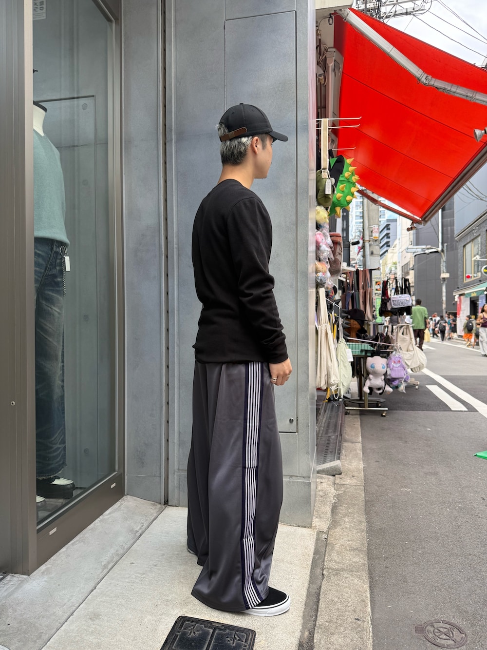 ブラック系のトップス、グレー系のパンツを着用したメンズの秋コーディネートの2枚目の写真