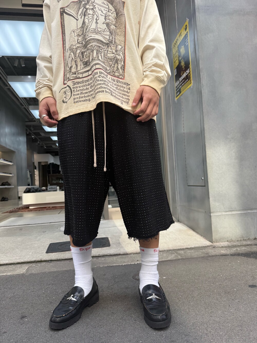 ベージュ系のTシャツ/カットソー、ブラック系のスウェットパンツを着用したメンズの夏コーディネートの5枚目の写真
