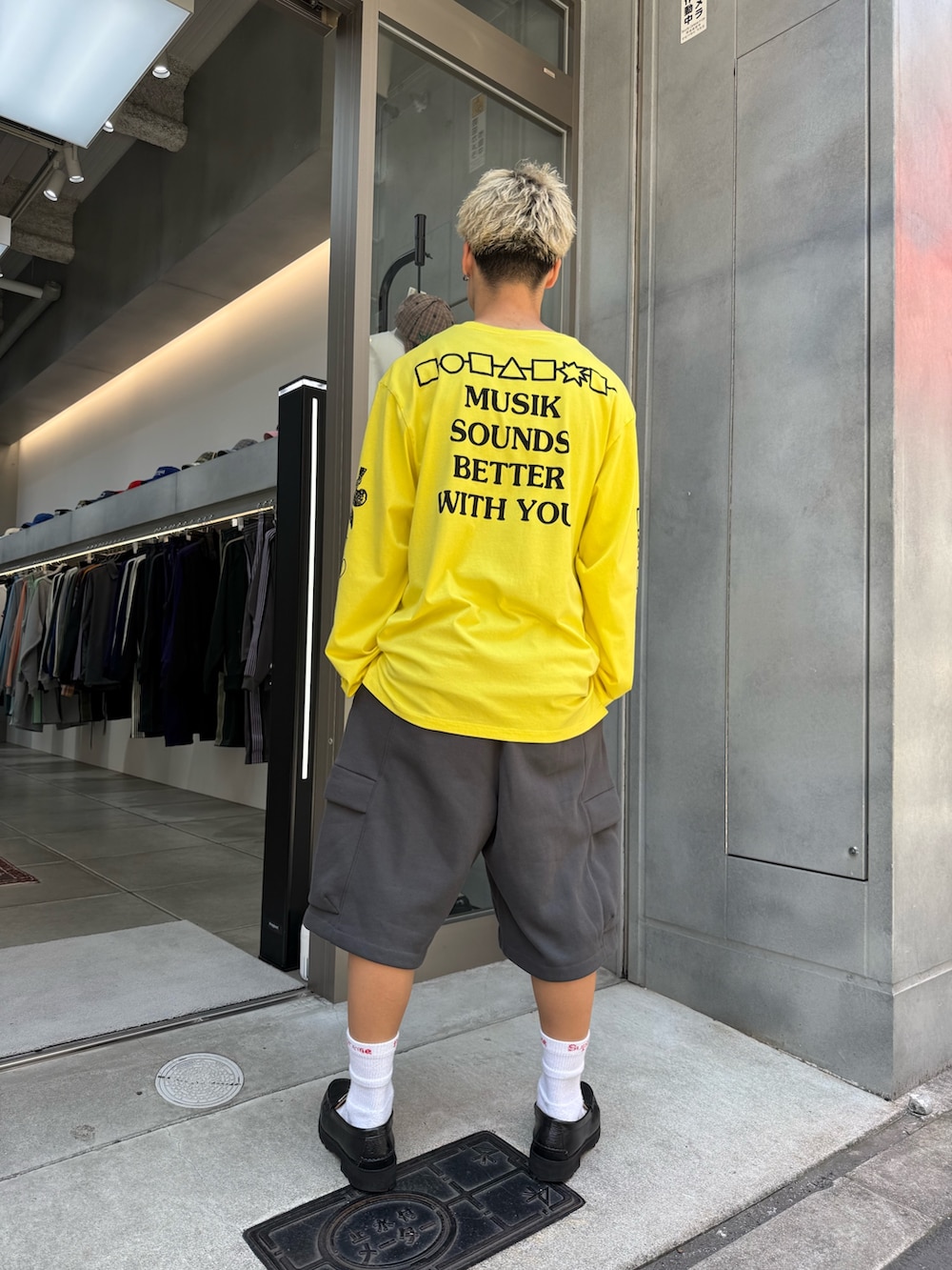 イエロー系のTシャツ/カットソー、グレー系のカーゴパンツ、ブラック系のローファーを着用したメンズの夏コーディネートの3枚目の写真
