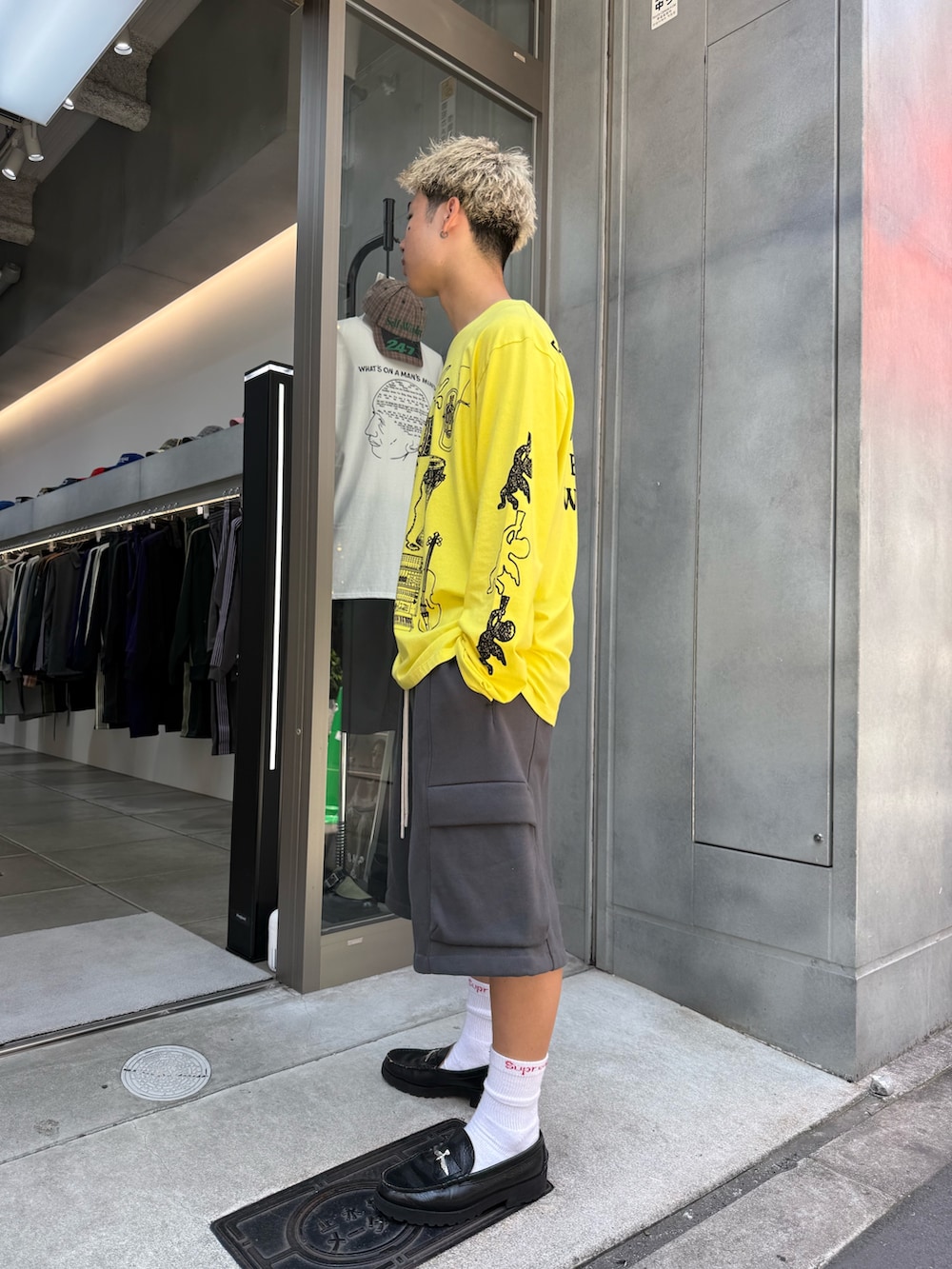 イエロー系のTシャツ/カットソー、グレー系のカーゴパンツ、ブラック系のローファーを着用したメンズの夏コーディネートの2枚目の写真