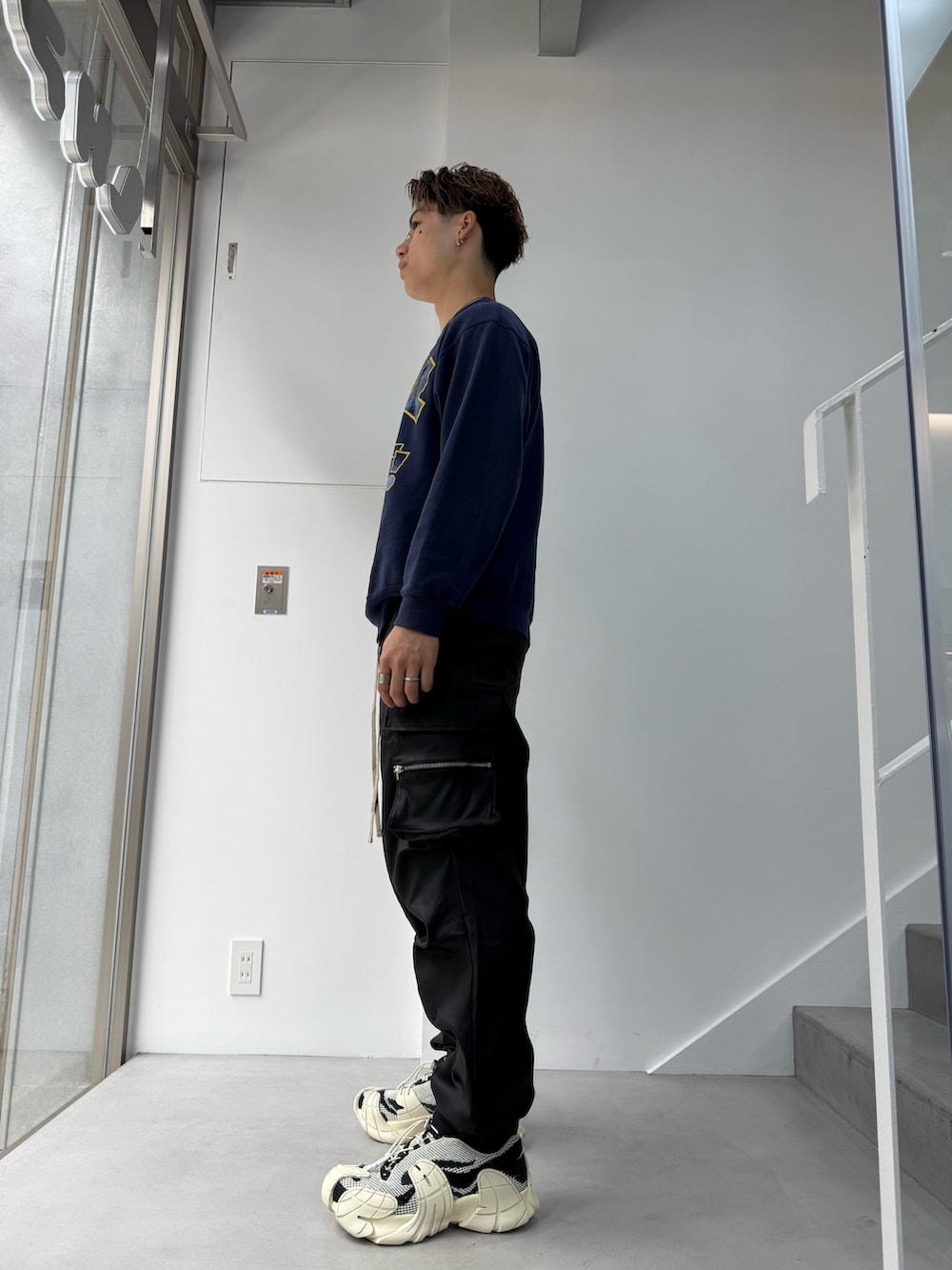 ブラック系のカーゴパンツを着用したメンズの春コーディネートの2枚目の写真