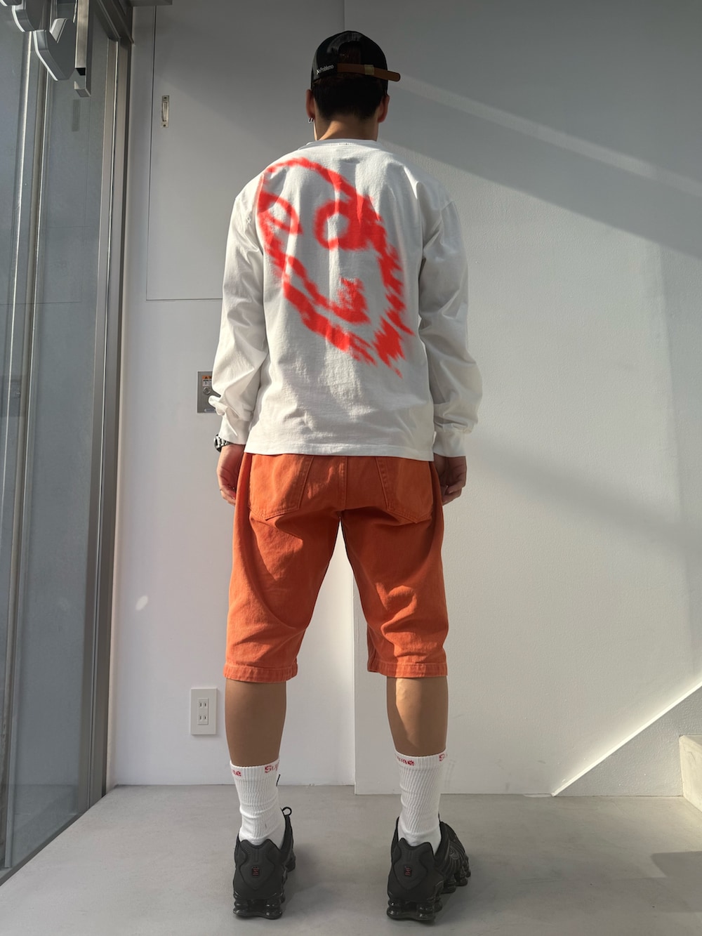 ホワイト系のTシャツ/カットソー、オレンジ系のデニムパンツを着用したメンズの春コーディネートの3枚目の写真
