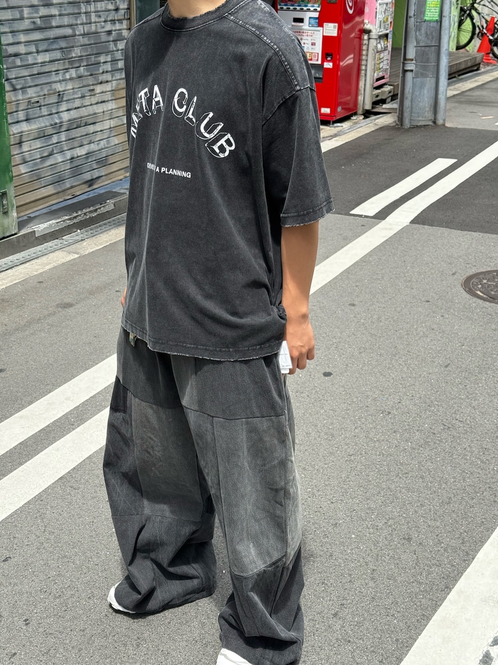 ブラック系のTシャツ/カットソー、ブラック系のチノパンツを着用したメンズの夏コーディネートの6枚目の写真
