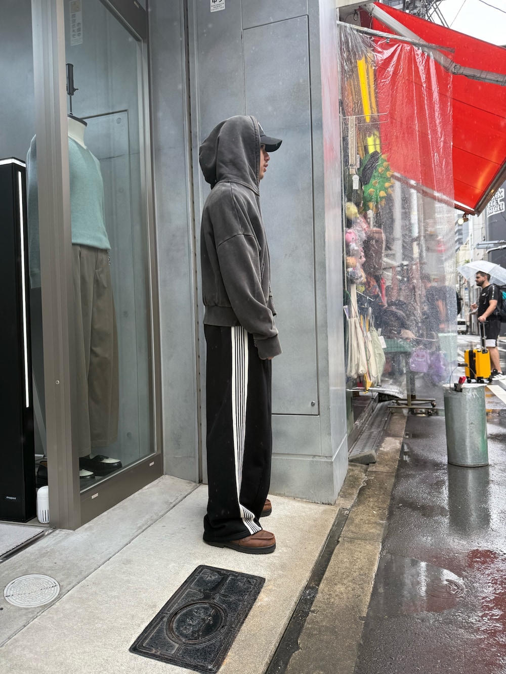 ブラック系のパーカー、ブラック系のスウェットパンツを着用したメンズの秋コーディネートの2枚目の写真