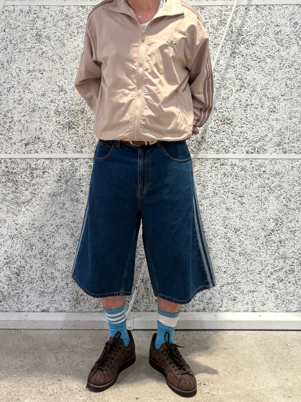 ブルー系のデニムパンツ、ブラウン系のスニーカーを着用したメンズの夏コーディネートの2枚目の写真
