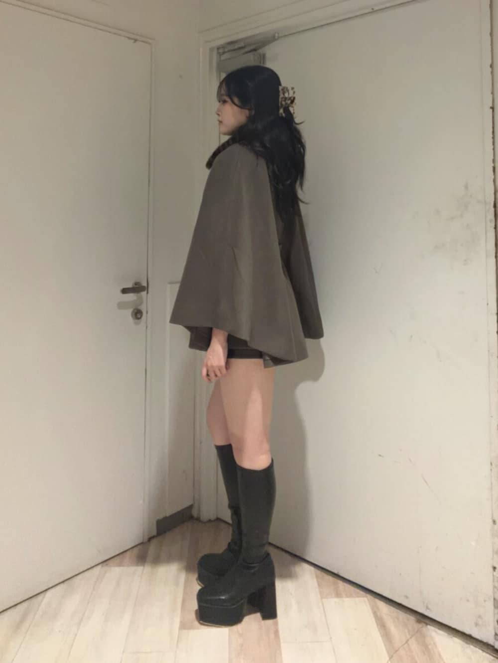ブラウン系のその他アウター、ブラック系のその他パンツ、ブラック系のブーツを着用したレディースの秋コーディネートの2枚目の写真