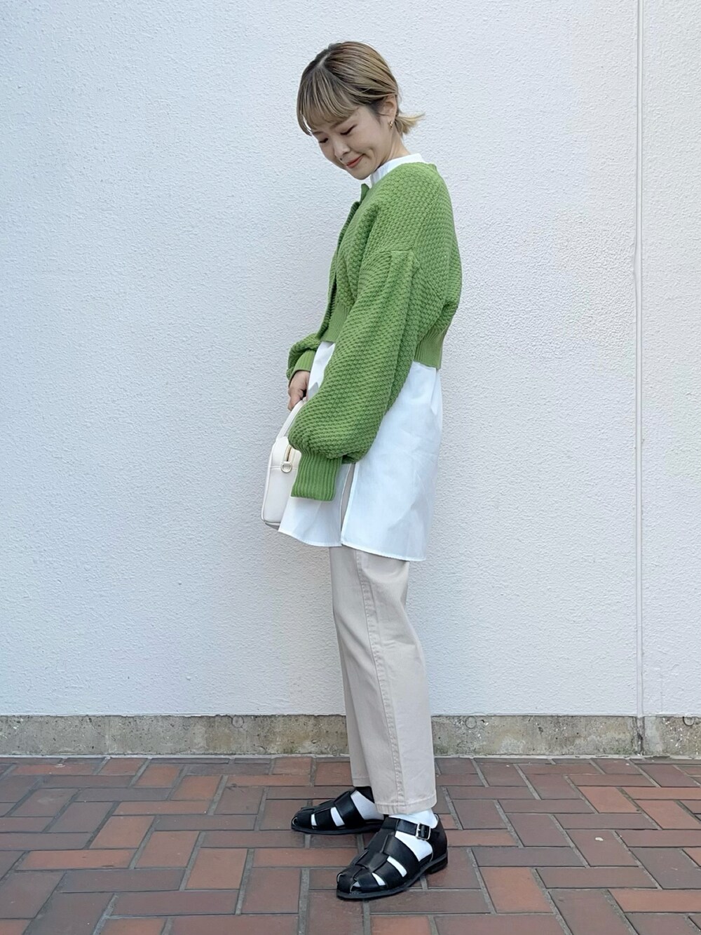 グリーン系のカーディガン/ボレロ、ベージュ系のその他パンツ、ブラック系のシューズを着用したレディースの冬コーディネートの2枚目の写真