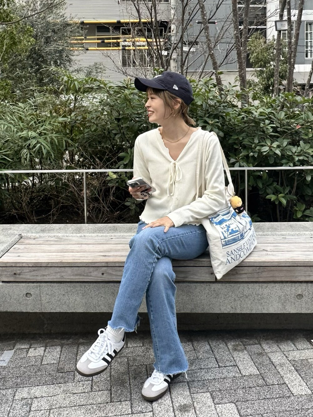 ホワイト系のカーディガン/ボレロ、ブルー系のデニムパンツを着用したレディースの春コーディネートの2枚目の写真