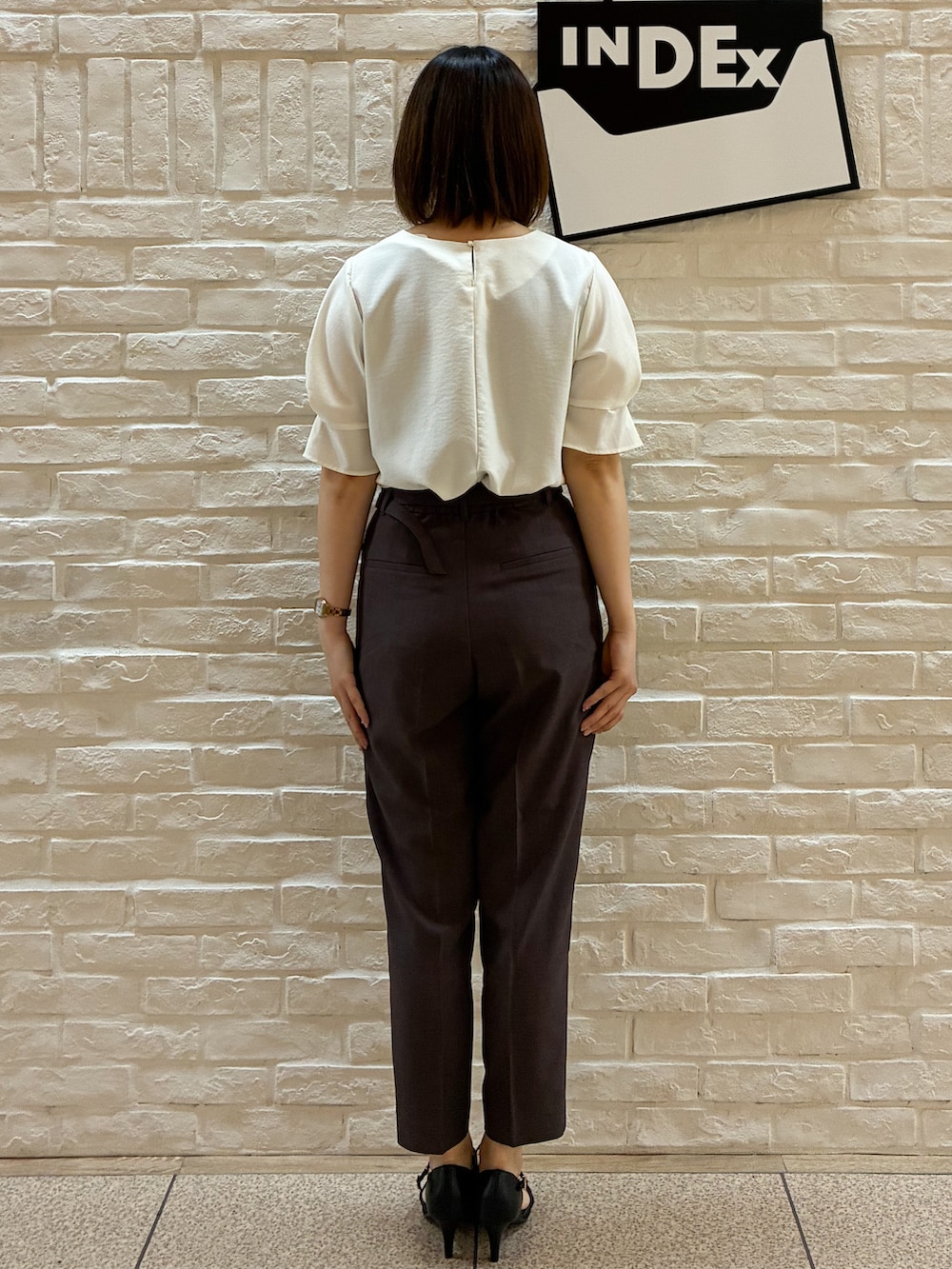 ホワイト系のシャツ/ブラウス、ブラウン系のその他パンツ、ベージュ系のトートバッグを着用したレディースの春コーディネートの3枚目の写真