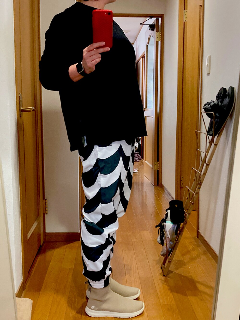 ブラック系のスウェット、ブラック系のスウェットパンツ、ベージュ系のスニーカーを着用したレディースの秋コーディネートの2枚目の写真