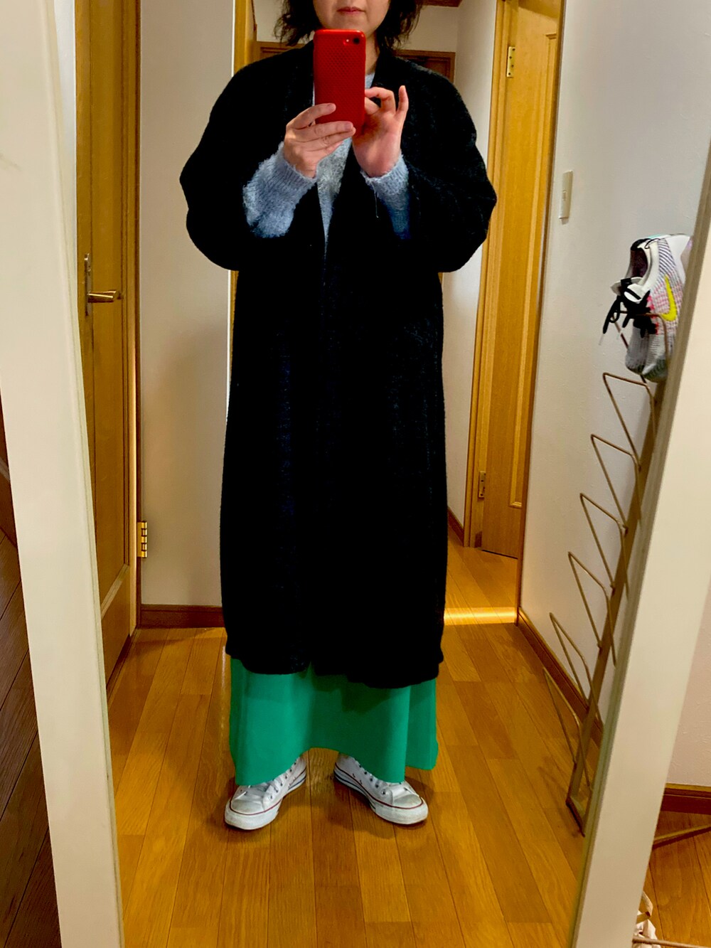 ブルー系のニット/セーター、グリーン系のスカート、ホワイト系のスニーカーを着用したレディースの冬コーディネートの3枚目の写真