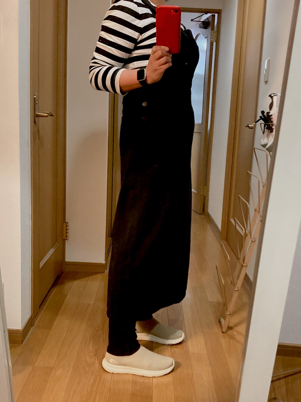 ブラック系のジャンパースカート、ベージュ系のスニーカー、ブラウン系のカーディガン/ボレロを着用したレディースの秋コーディネートの3枚目の写真