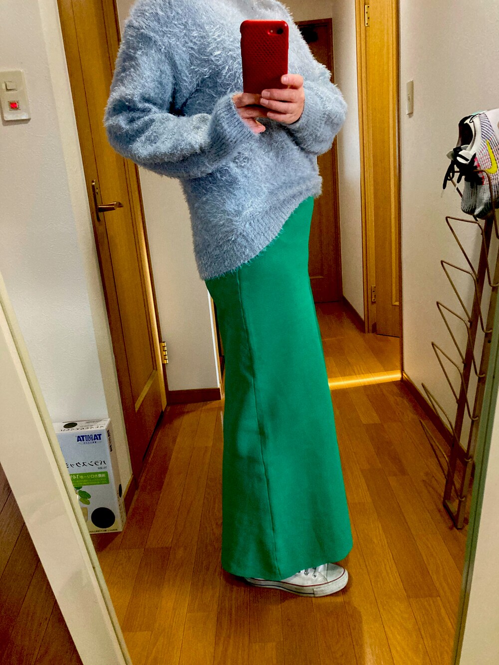 ブルー系のニット/セーター、グリーン系のスカート、ホワイト系のスニーカーを着用したレディースの冬コーディネートの2枚目の写真