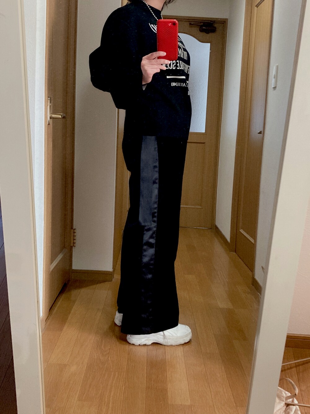 ブラック系のパンツ、ホワイト系のスニーカー、ブラック系のニット/セーターを着用したレディースの冬コーディネートの2枚目の写真