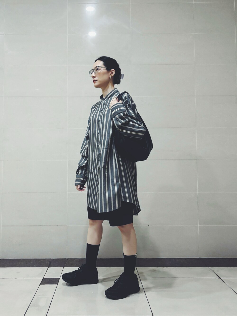 グレー系のシャツ/ブラウス、ブラック系のスニーカー、ブラック系のハンドバッグを着用したレディースの秋コーディネートの2枚目の写真