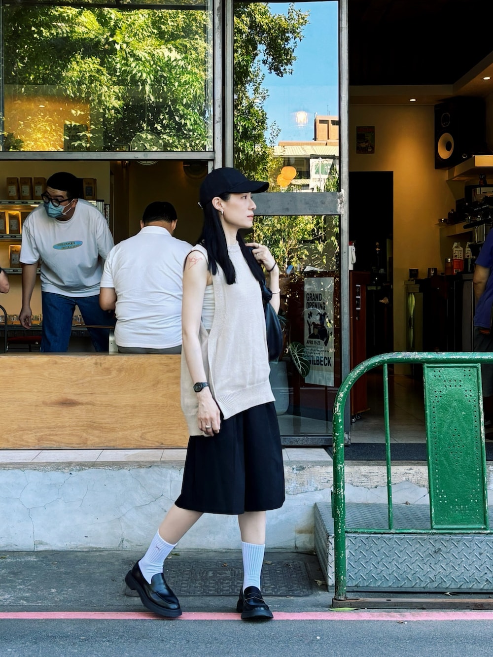 ベージュ系のベスト、ブラック系のローファー、ブラック系のハンドバッグを着用したレディースの秋コーディネートの3枚目の写真