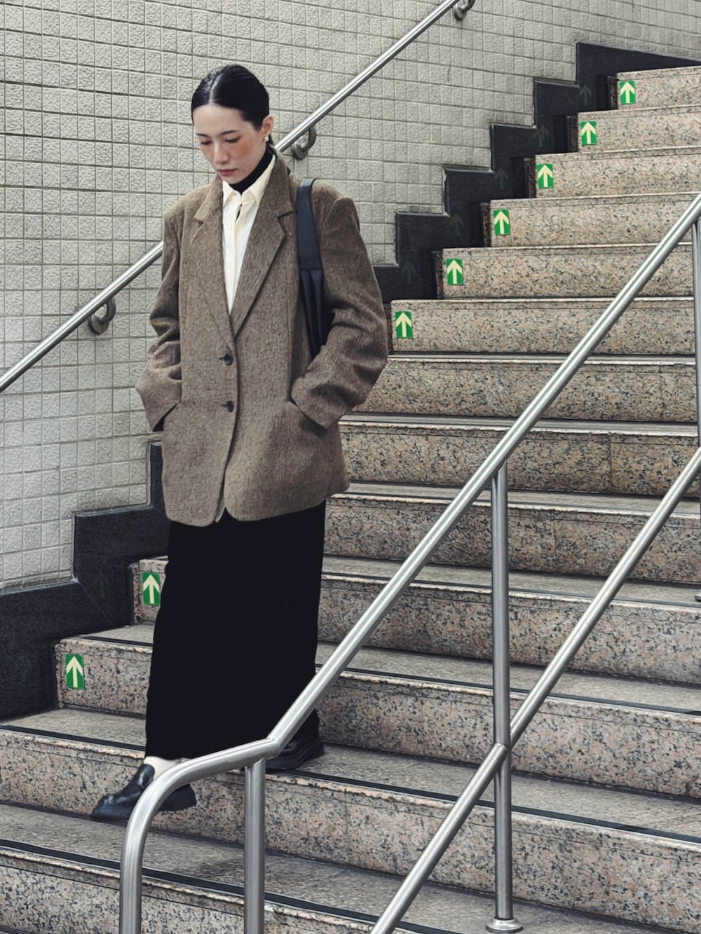 ベージュ系のテーラードジャケット、ホワイト系のシャツ/ブラウス、ブラック系のスカートを着用したレディースの春コーディネートの2枚目の写真