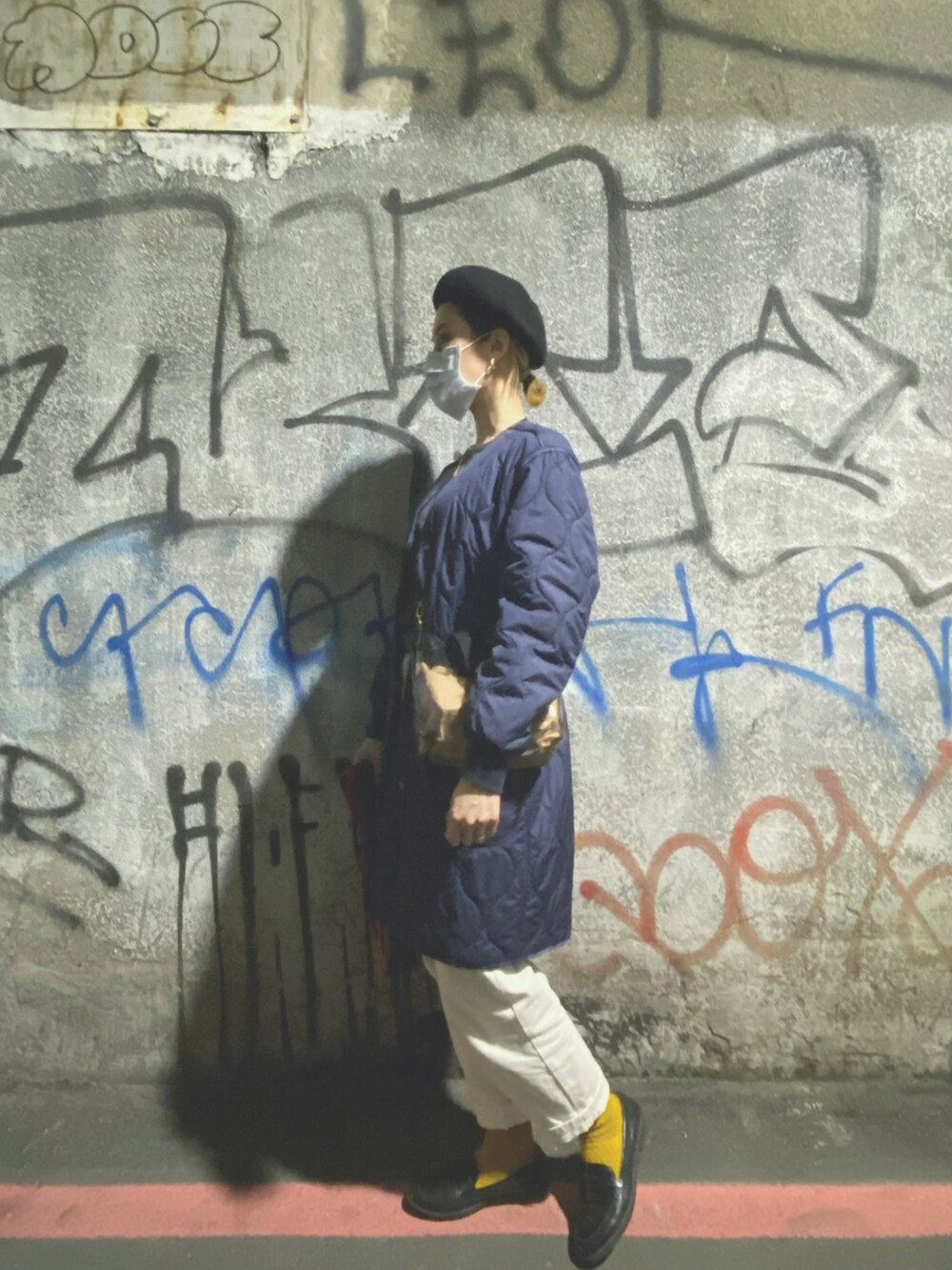 ブルー系のミリタリージャケット、ホワイト系のその他パンツ、ブラック系のショルダーバッグを着用したレディースの冬コーディネートの2枚目の写真