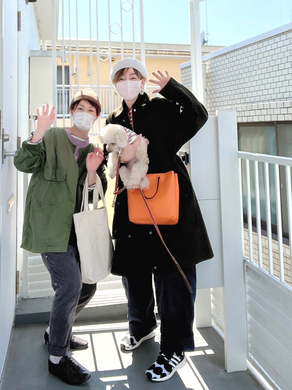 オレンジ系のTシャツ/カットソー、ブラック系のスニーカー、ピンク系のペットウェアを着用したレディースの春コーディネートの2枚目の写真