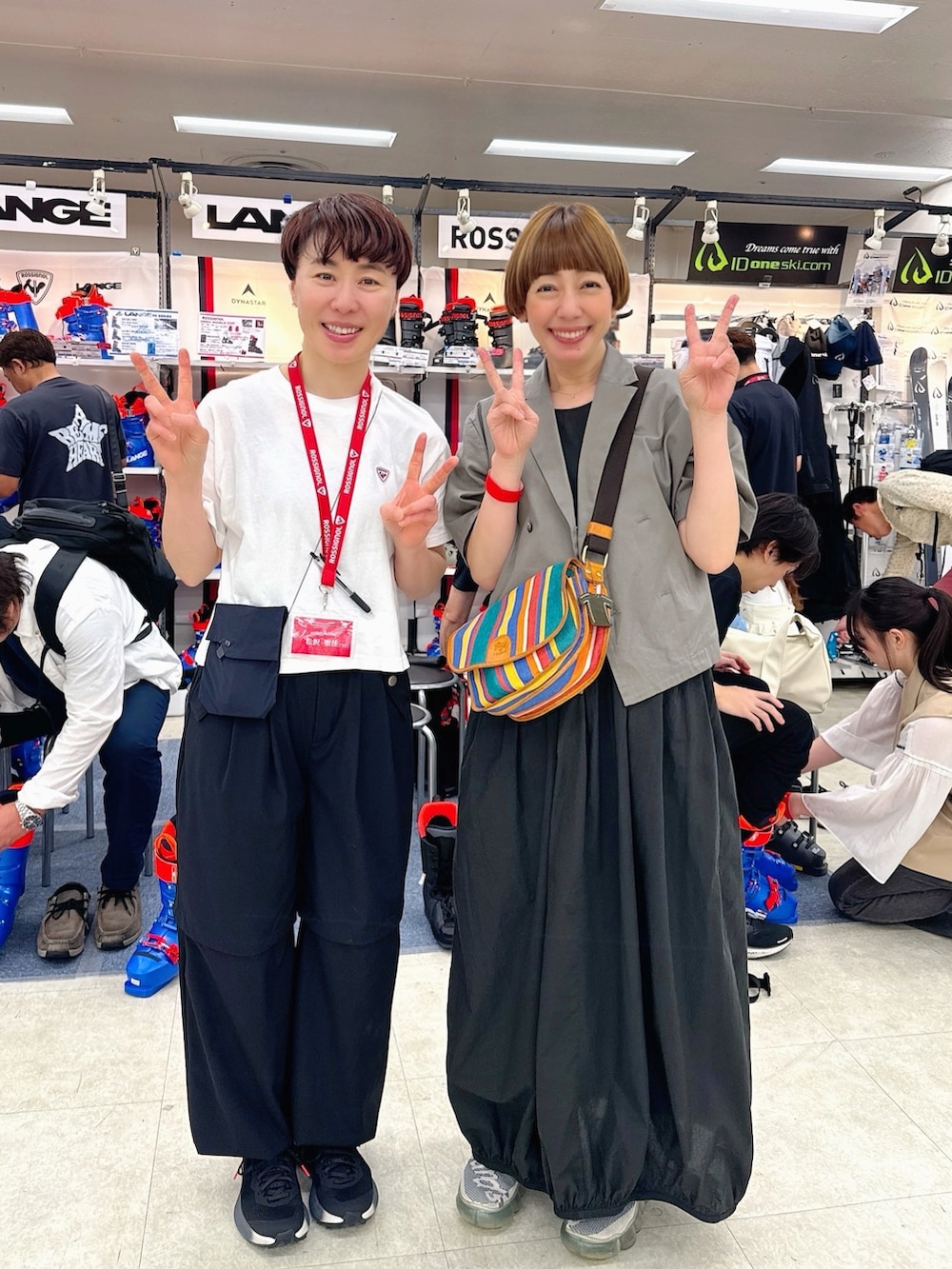 グレー系のサロペット/オーバーオール、ブラック系のワンピース、ホワイト系のスニーカーを着用したレディースの夏コーディネートの3枚目の写真