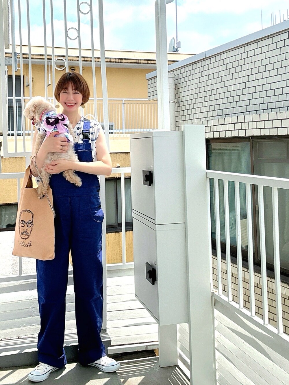 ホワイト系のシャツ/ブラウス、ブルー系のサロペット/オーバーオール、ベージュ系のエコバッグ/サブバッグを着用したレディースの夏コーディネートの2枚目の写真