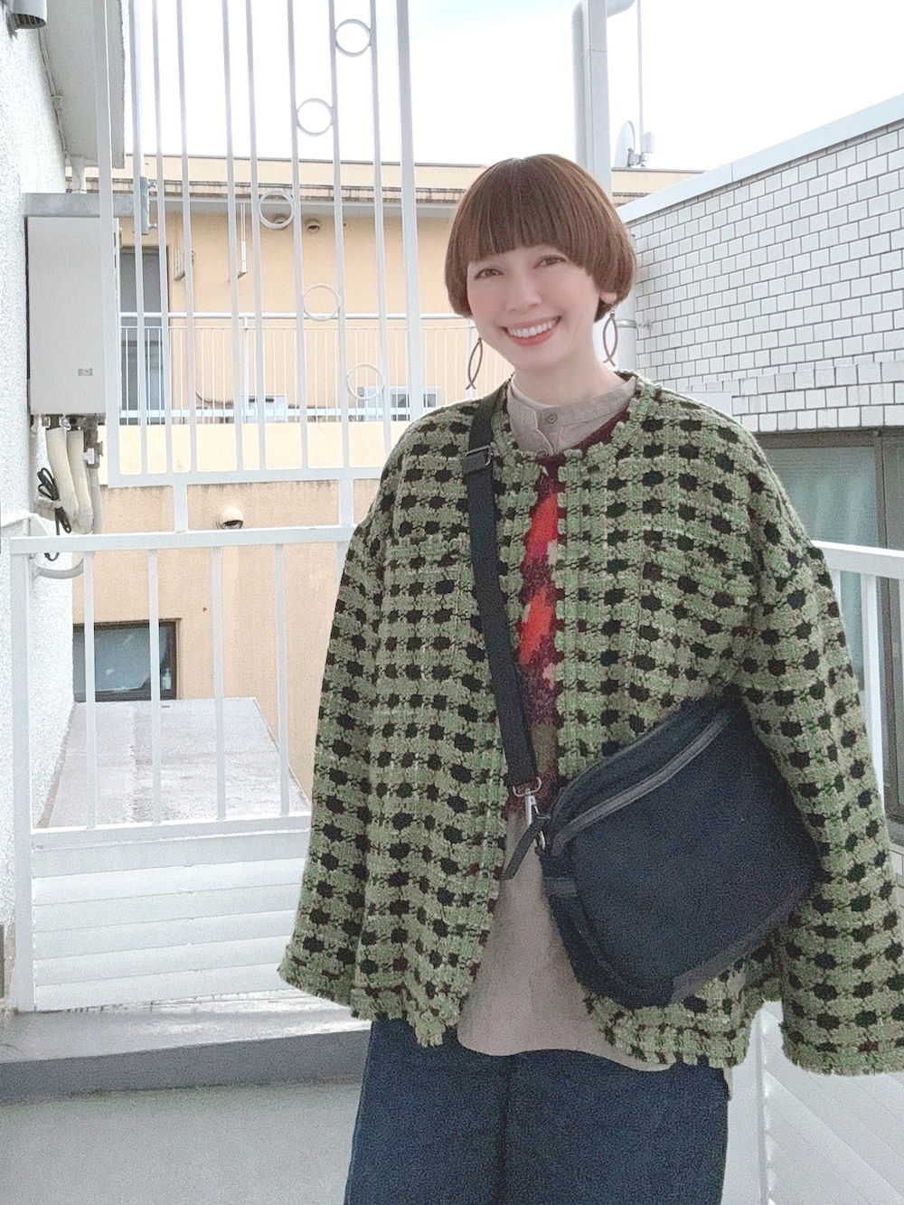 グリーン系のダウンベスト、その他のニット/セーター、グリーン系のその他アウターを着用したレディースの冬コーディネートの2枚目の写真