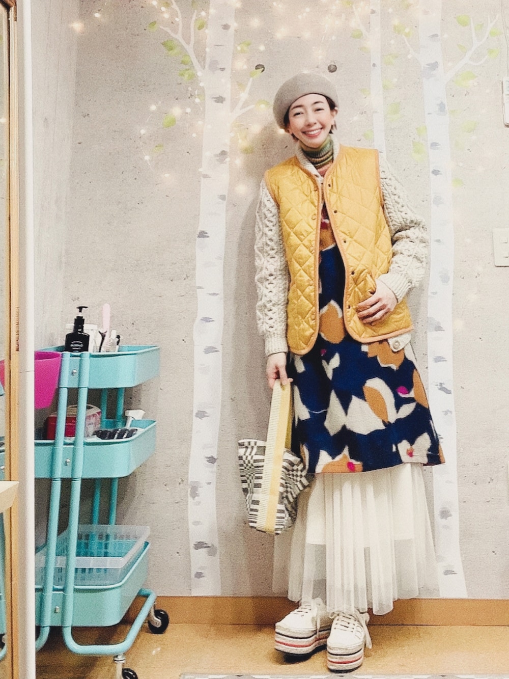 ブルー系のベスト、その他のニット/セーター、イエロー系のダウンベストを着用したレディースの冬コーディネートの2枚目の写真