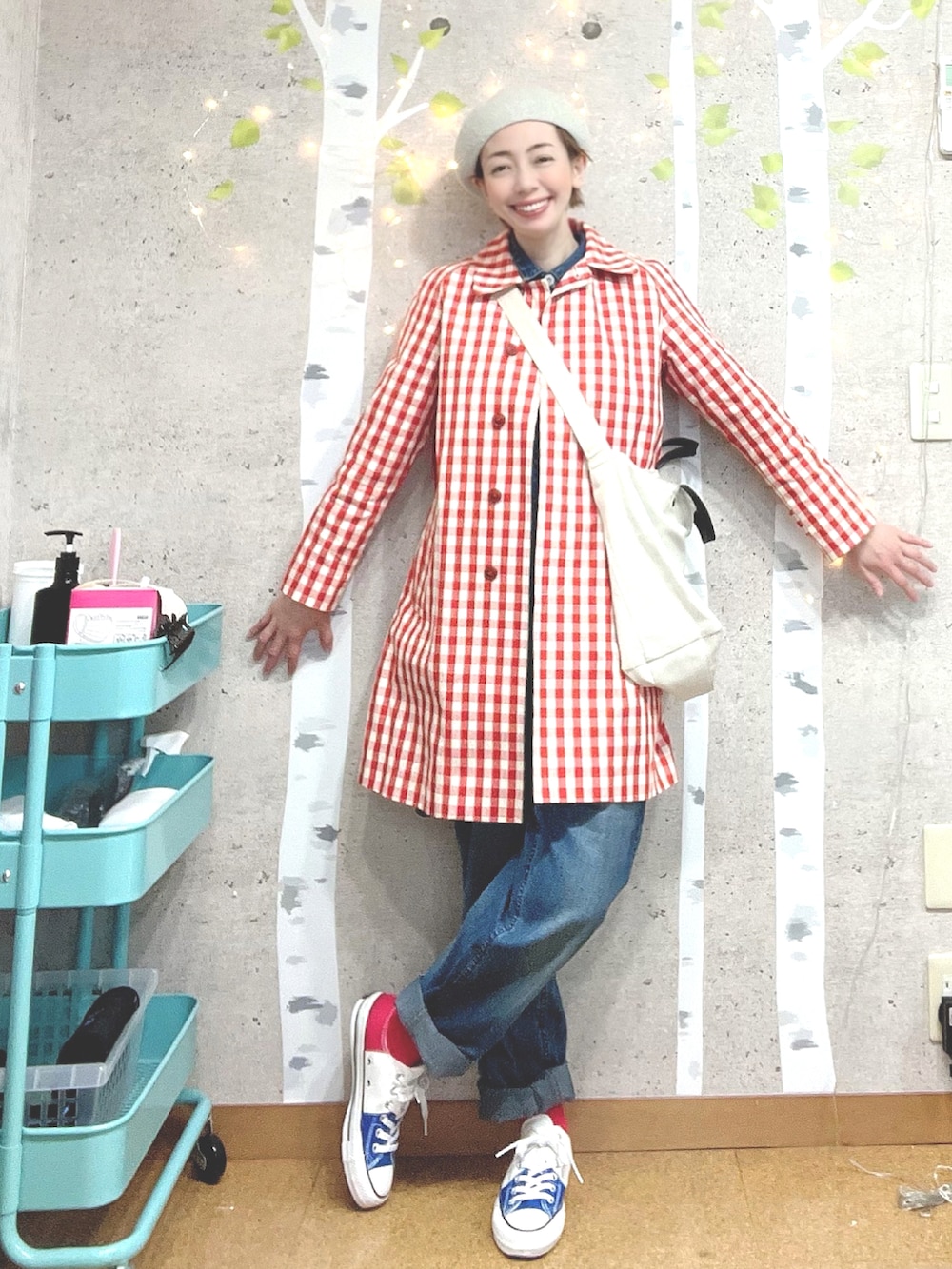 レッド系のチェスターコート、ブルー系のつなぎ/オールインワン、ホワイト系のトートバッグを着用したレディースの春コーディネートの2枚目の写真