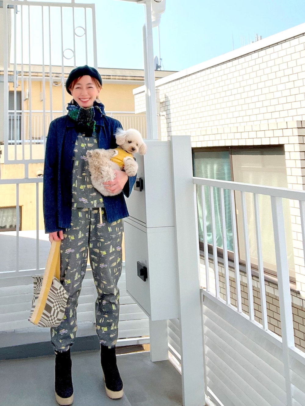 イエロー系のハンドバッグ、ブルー系のシャツ/ブラウス、グレー系のTシャツ/カットソーを着用したレディースの春コーディネートの2枚目の写真