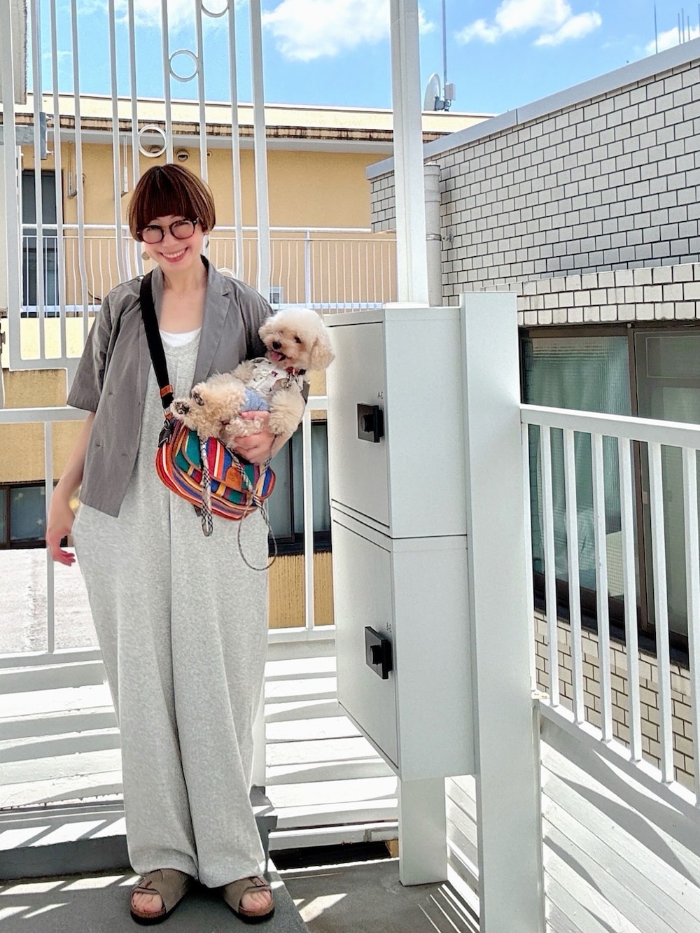 グレー系のサロペット/オーバーオール、ブラック系のワンピース、ホワイト系のスニーカーを着用したレディースの夏コーディネートの2枚目の写真