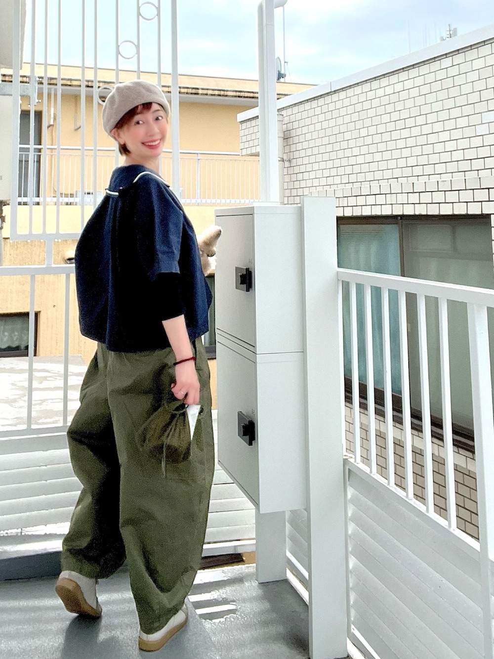 ブルー系のシャツ/ブラウス、グリーン系のバッグ、グレー系のスニーカーを着用したレディースの秋コーディネートの2枚目の写真