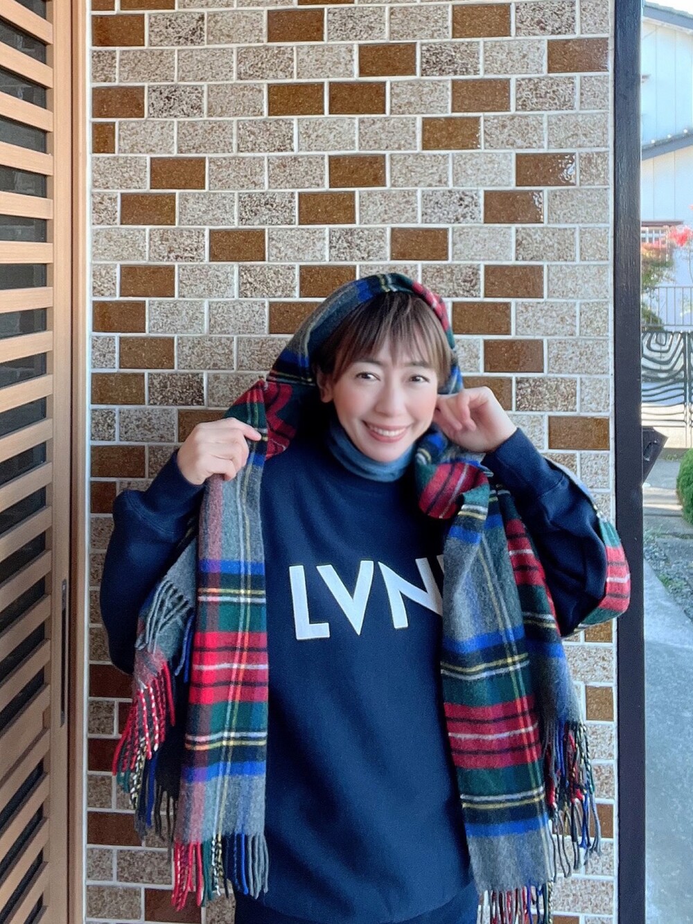 オレンジ系のショルダーバッグ、ブルー系のMA-1、レッド系のマフラーを着用したレディースの冬コーディネートの5枚目の写真