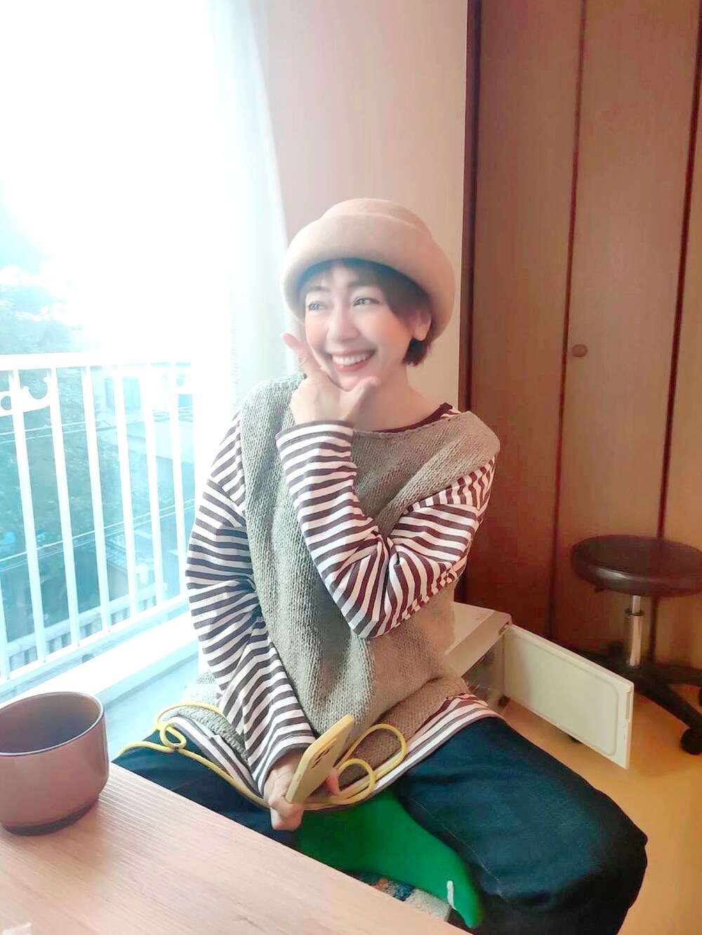 ベージュ系のベスト、ブラウン系のTシャツ/カットソー、ブルー系のデニムパンツを着用したレディースの秋コーディネートの2枚目の写真