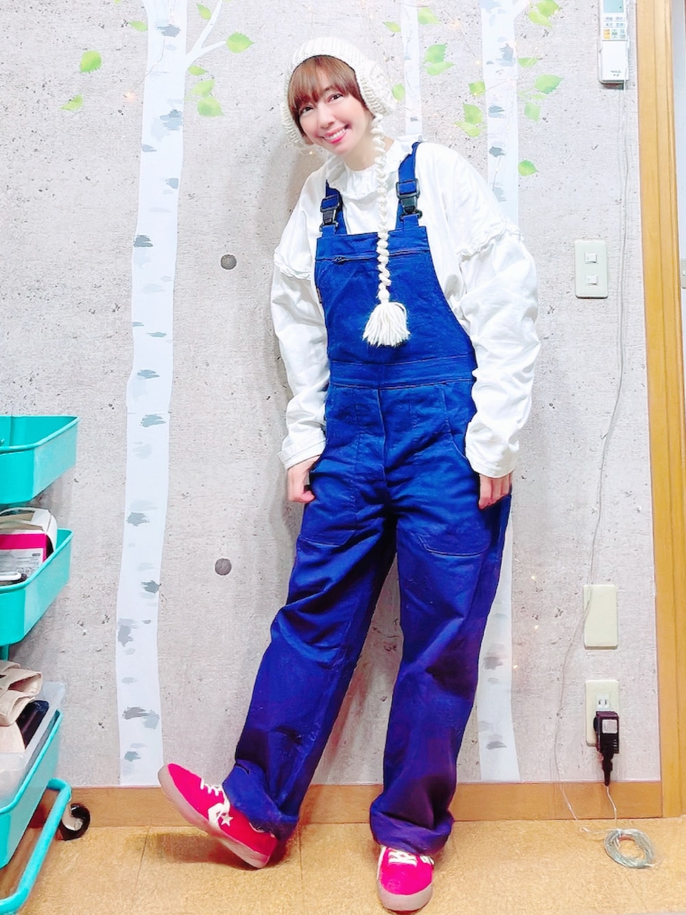 レッド系のスニーカー、ホワイト系のTシャツ/カットソー、ブルー系のサロペット/オーバーオールを着用したレディースの冬コーディネートの3枚目の写真