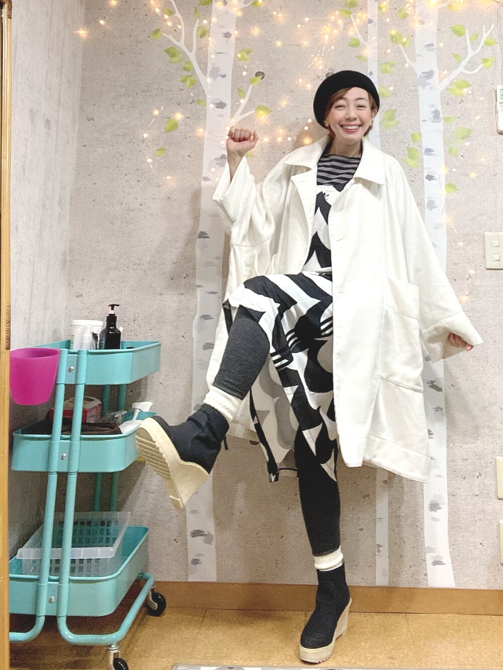 ホワイト系のその他アウター、ブラック系のワンピース、グレー系のTシャツ/カットソーを着用したレディースの冬コーディネートの3枚目の写真