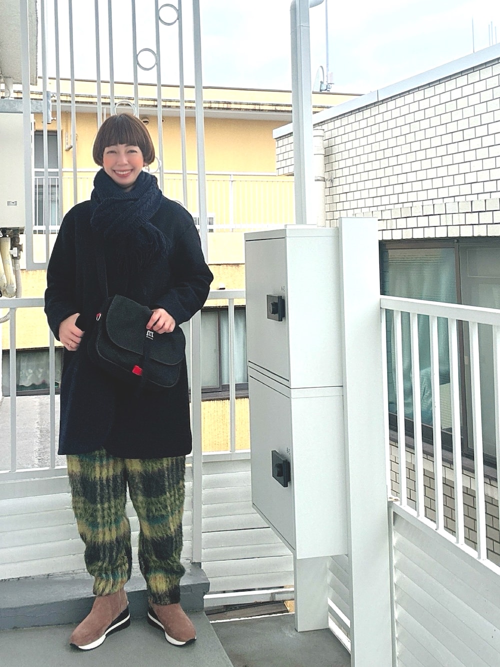 グリーン系のその他パンツ、グレー系のニット/セーター、ブラウン系のブーツを着用したレディースの冬コーディネートの2枚目の写真