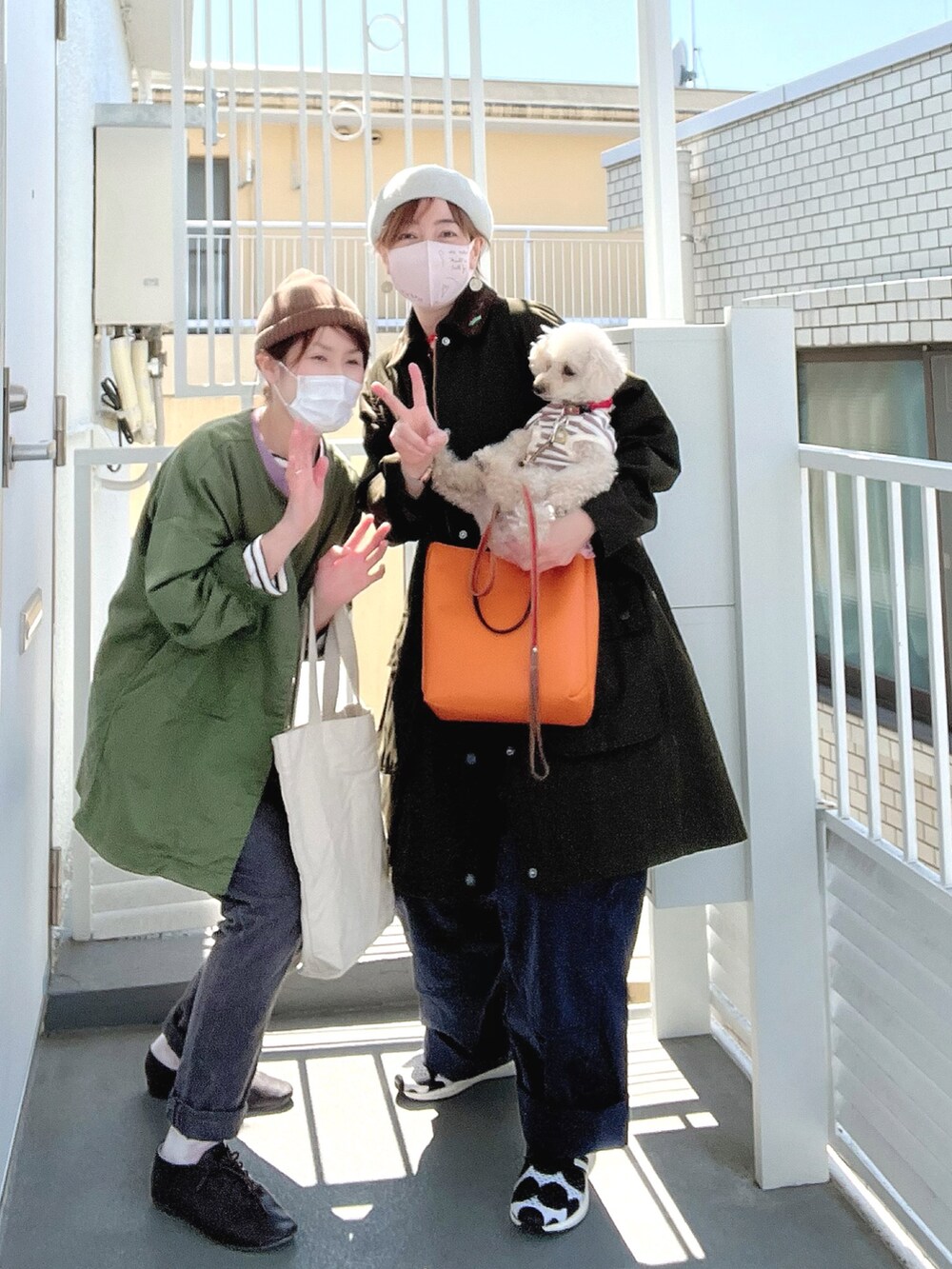 オレンジ系のTシャツ/カットソー、ブラック系のスニーカー、ピンク系のペットウェアを着用したレディースの春コーディネートの3枚目の写真